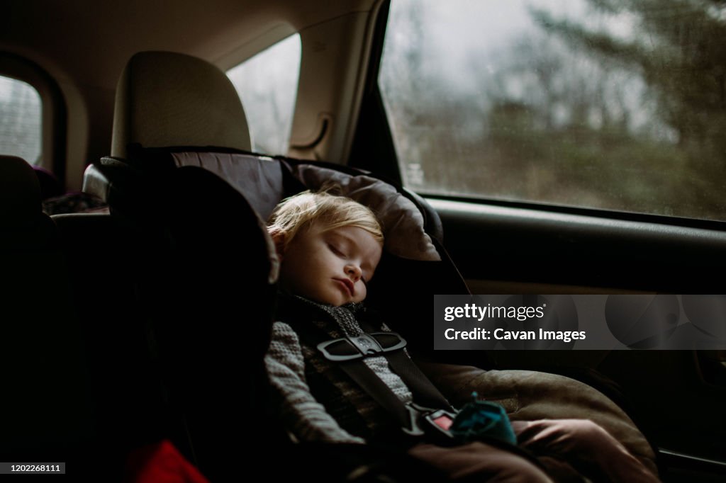 Toddler asleep in carseat on road trip