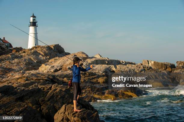 woman fly fishing near portland headlight in maine - cabo elizabeth fotografías e imágenes de stock