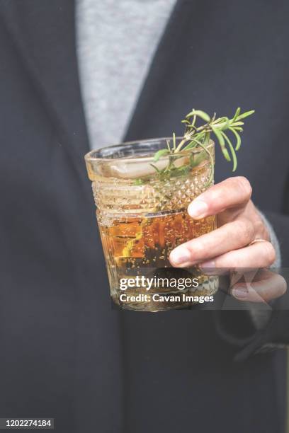 hand holding a gin cocktail - mint julep stock-fotos und bilder