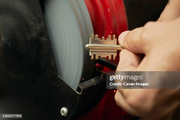 closed image of duplicate key in the process of sanding by the locksmith to eliminate burrs - veicolo blindato foto e immagini stock