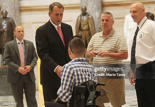 Speaker of the House John Boehner greets U.S. Marine Cpl. Todd Love, who was injured in Afghanistan, as Boehner walks towards the House chamber for...