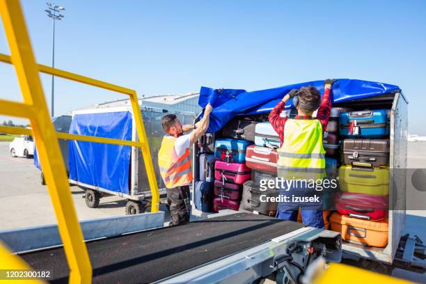 airport service crew loading luggage - ground crew stock pictures, royalty-free photos & images