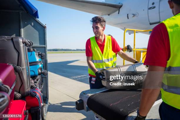 airport service crew unloading luggage - airport crew stock pictures, royalty-free photos & images