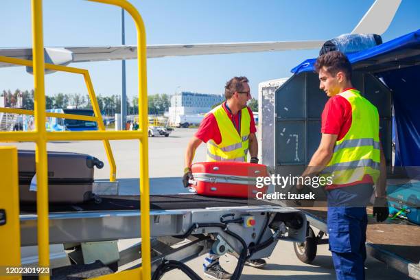 airport service crew unloading luggage - unloading airplane stock pictures, royalty-free photos & images