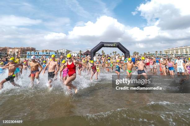 a swimmer kids crowd running to the water after a open water competition had start - kids swim caps stock pictures, royalty-free photos & images