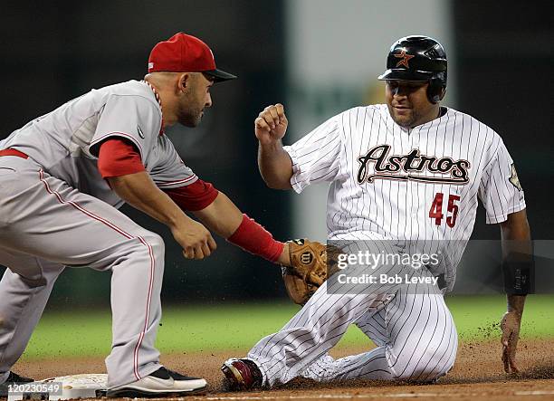 Carlos Lee of the Houston Astros is tagged out by third baseman Miguel Cairo of the Cincinnati Reds in the second inning at Minute Maid Park on...