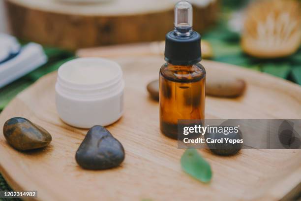 close-up image of essential oils bottle, flowers, and stones - lastone therapy stock pictures, royalty-free photos & images