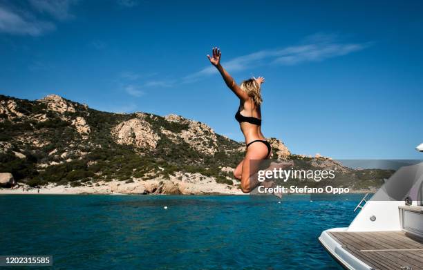 woman jumping into sea from yacht, la maddalena island, sardegna, italy - jumping of boat photos et images de collection