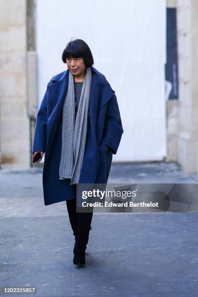 Angelica Cheng wears a gray wool long scarf, a long blue coat, black boots, outside Maison Margiela, during Paris Fashion Week - Haute Couture...