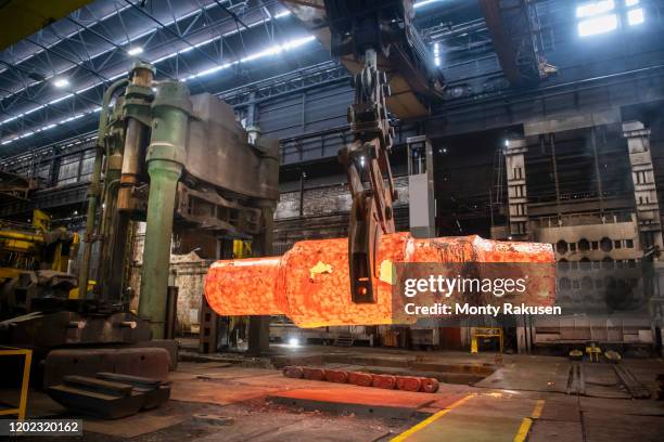 red hot steel ingot being craned to forge in steelworks - steelmaking stock pictures, royalty-free photos & images