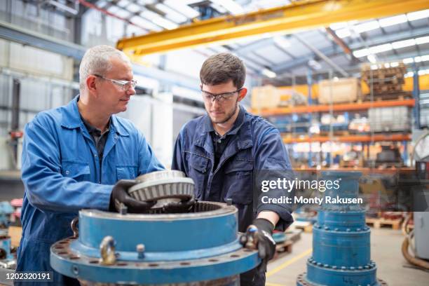 engineer and apprentice installing bearings into pump house in electrical engineering factory - trainee stock pictures, royalty-free photos & images