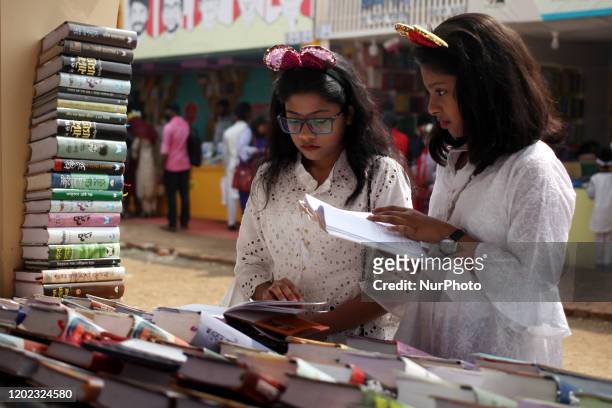 Girls check books at a stall during Ekushe Boimela Book Fair at Suhrawardy Udyan in Dhaka, Bangladeh on Friday, Feb. 21, 2020.