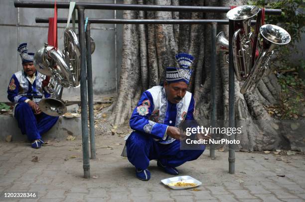 Musicians of a local brass band company have lunch before the procession of Maha Shivaratri festival , celebrated in the reverence of Hindu God Shiva...