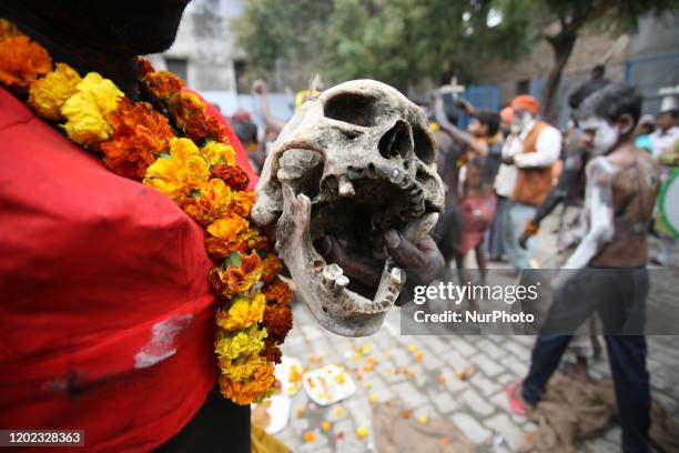 An artist performs with a human skull and bones during the procession of Maha Shivaratri festival , celebrated in the reverence of Hindu God Shiva ,...