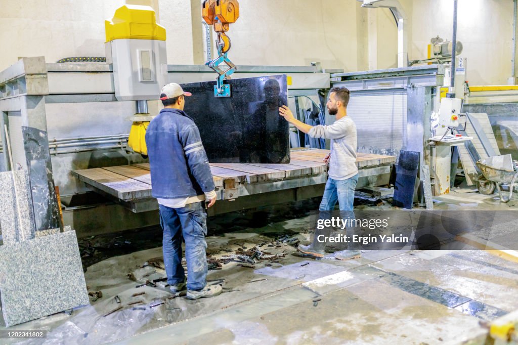 Marble factory workers with crane