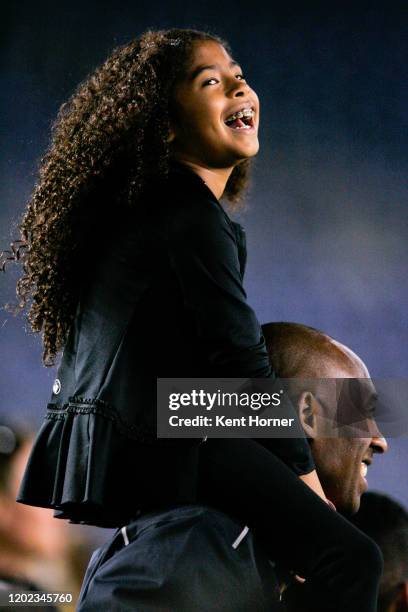 Los Angeles Laker Kobe Bryant stands on the sideline with his daughter Gianna Maria-Onore Bryant on his shoulders prior to the start of the game...