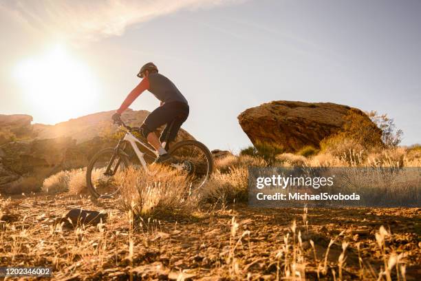 mountain biker riding through boulders in the southwest desert - st george utah stock pictures, royalty-free photos & images