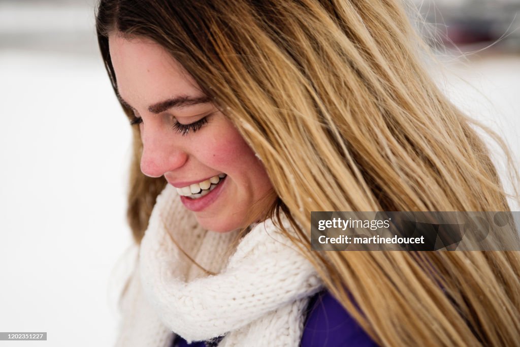 Generation Z young woman in snowy public park.