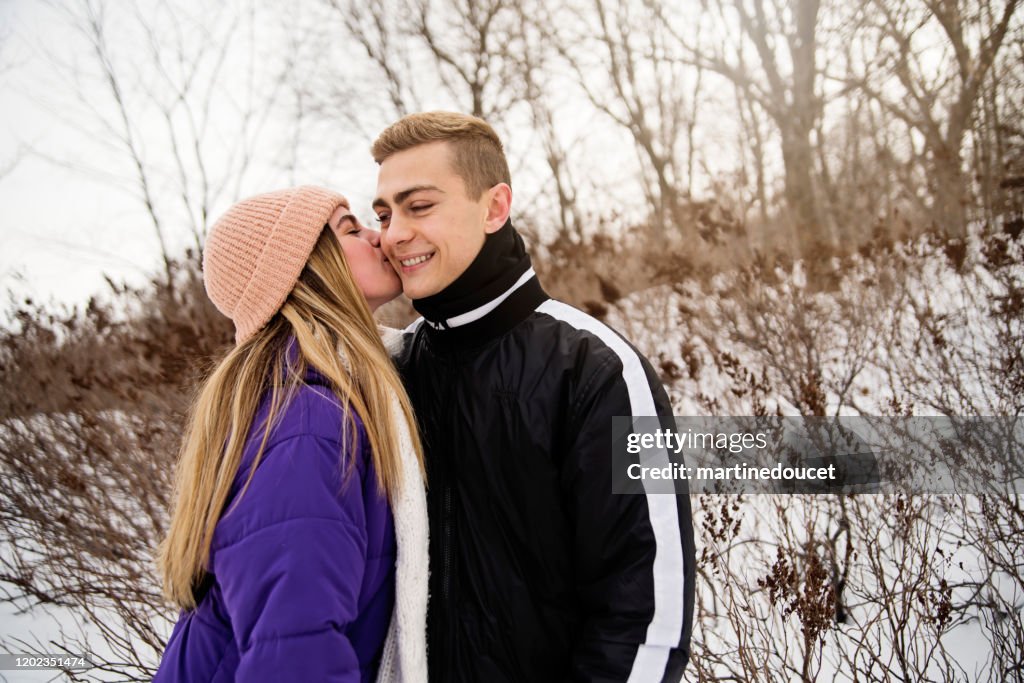 Z世代夫婦在冬天在雪地公園的小徑上散步。