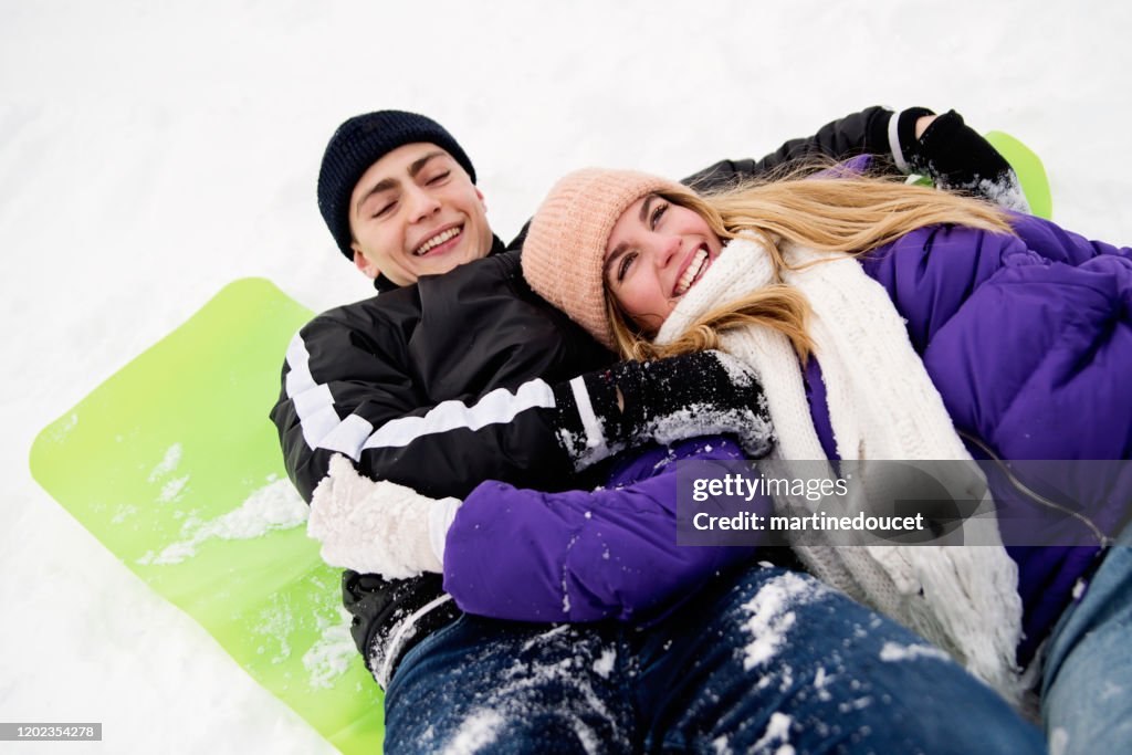 Generation Z couple playing in snowy public park.