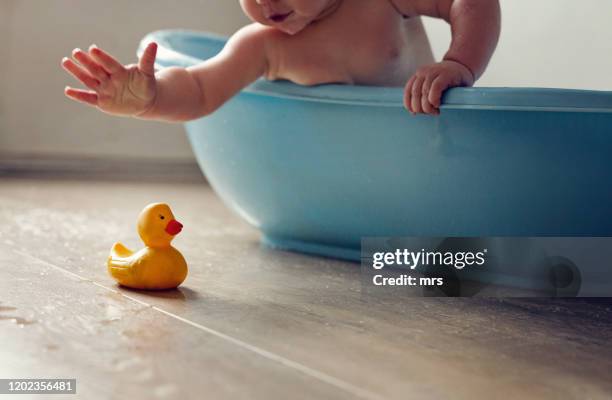 baby in bath tub - badeend stockfoto's en -beelden