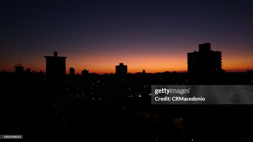 The sunset and the silhouette of the city.