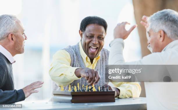 men playing chess, winning move - senior playing chess stock pictures, royalty-free photos & images