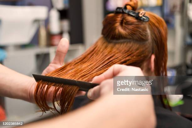 peluquería peinando el cabello mojado de una mujer pelirroja - thick white women fotografías e imágenes de stock