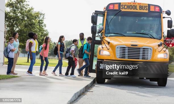 autobus d'embarquement de classe d'école moyenne, garçon avec le syndrome de vers le bas - school bus stock photos et images de collection