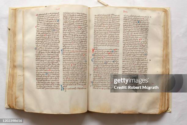 inside double page spread on bound medieval manuscript showing layout and calligraphic lettering with drop capitals and other highlighted letters. - vellum stock pictures, royalty-free photos & images