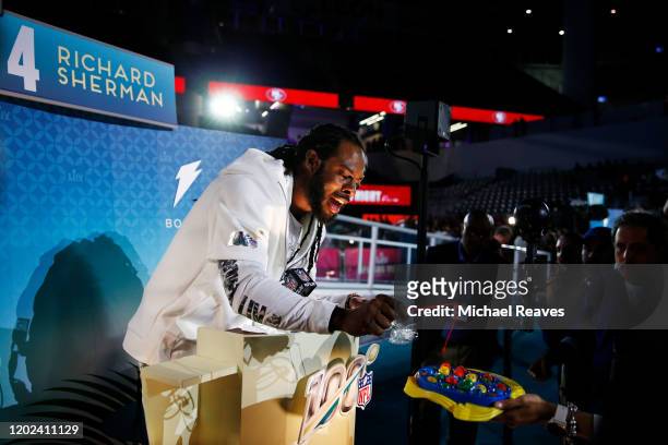 Cornerback Richard Sherman of the San Francisco 49ers speaks to the media during Super Bowl Opening Night presented by BOLT24 at Marlins Park on...