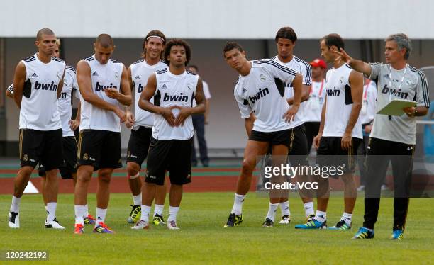 Players of Real Madrid listen to coach Jose Mourinho during a training session at Tianhe Sports Center on August 1, 2011 in Guangzhou, China.