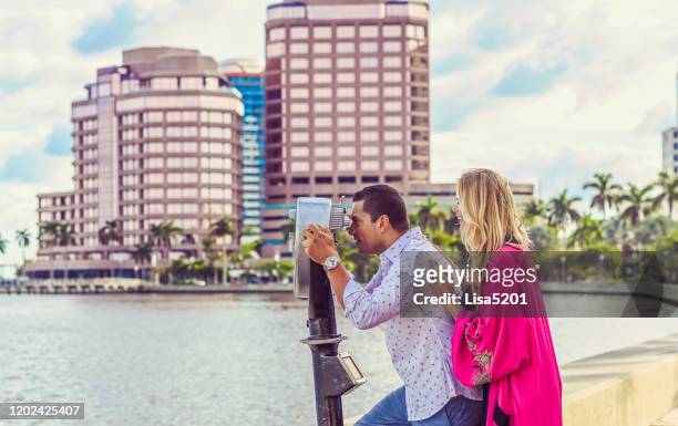 hermosa pareja explorar nueva ciudad y mirar a través del visor de la torre - west palm beach fotografías e imágenes de stock