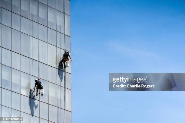 window cleaners cleaning building - city cleaning stock-fotos und bilder