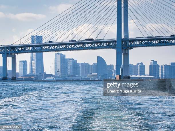 yokohama skyline over yokohama bay bridge - yokohama bay bridge stock pictures, royalty-free photos & images