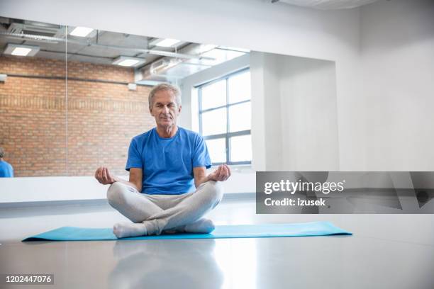 senior mann meditieren im health club, stockfoto - senior yoga stock-fotos und bilder