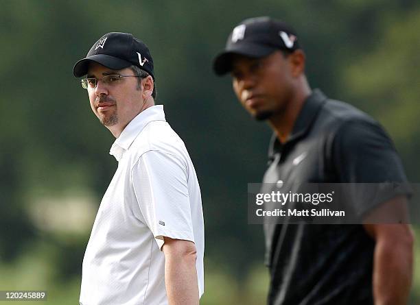 Tiger Woods and his caddie, Bryon Bell, watch a shot on the fourth hole during a practice round for the World Golf Championships Bridgestone...