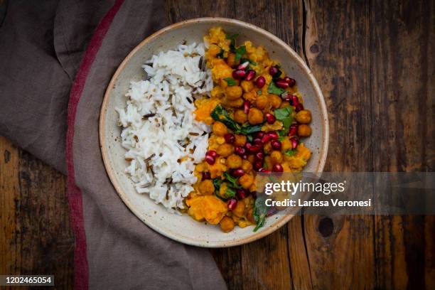 bowl of sweet potato lentil curry with basmati rice - koriander stock-fotos und bilder