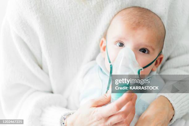 baby getting breathing treatment from mother - zichtbare adem stockfoto's en -beelden