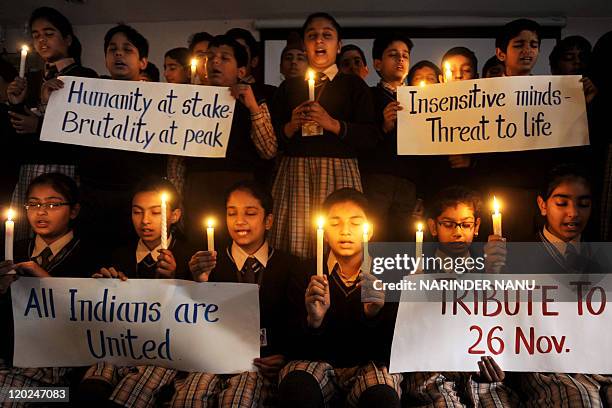 Indian school girls hold candles and signs at DAV Public school in Amritsar on November 26, 2010 in tribute to those killed in the 26/11 Mumbai...