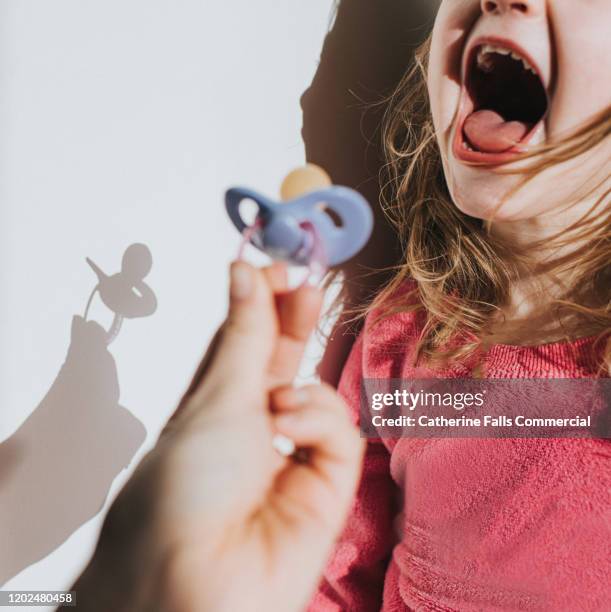 confiscating pacifier - pacifier stockfoto's en -beelden