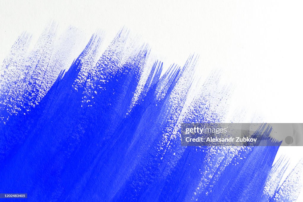 Abstract Background with Streaks of Blue Paint or Watercolor on a White Sheet. Copy Space For Text.