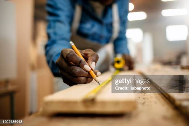 fermez-vous vers le haut de la vue des mains professionnelles laborieuse de femme de charpentier travaillant avec une règle et faisant des marques sur le bois - menuisier photos et images de collection