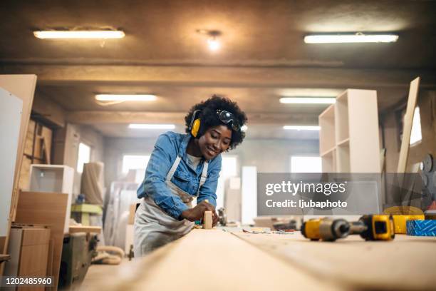 jonge vrouw die als timmerman werkt - carpentry stockfoto's en -beelden