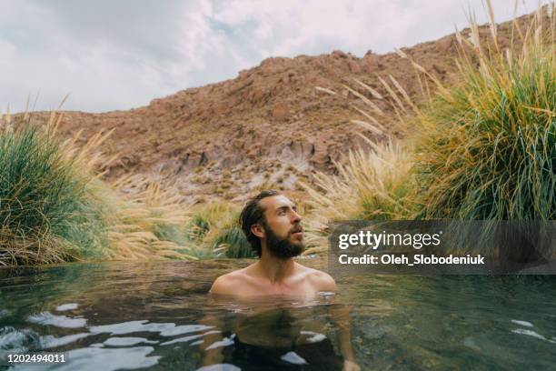 man in hot spring in atacama desert - chile desert stock pictures, royalty-free photos & images