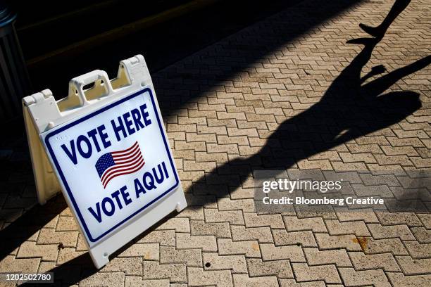 vote here sign in english and spanish - democracy day foto e immagini stock