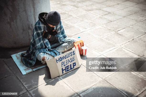 one man, young homeless sitting on the street and begging. - homeless man stock pictures, royalty-free photos & images