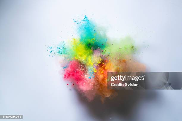 explode powder with white background captured with high speed sync. - orange powder stock pictures, royalty-free photos & images