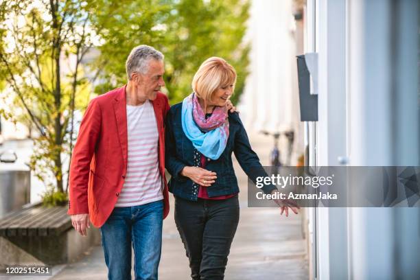 couple in their 60s enjoying window shopping in ljubljana - window shopping stock pictures, royalty-free photos & images