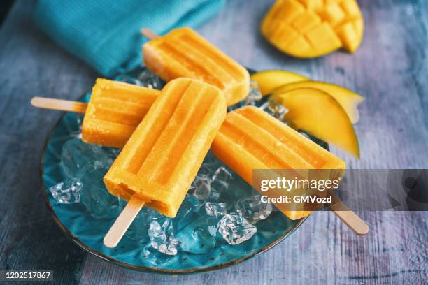 mango popsicle on ice - mango juice stock-fotos und bilder